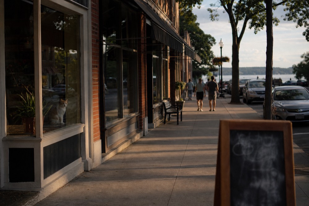 Quiet village street with storefronts near the southern tip of Keuka Lake, no text, no logos, no people