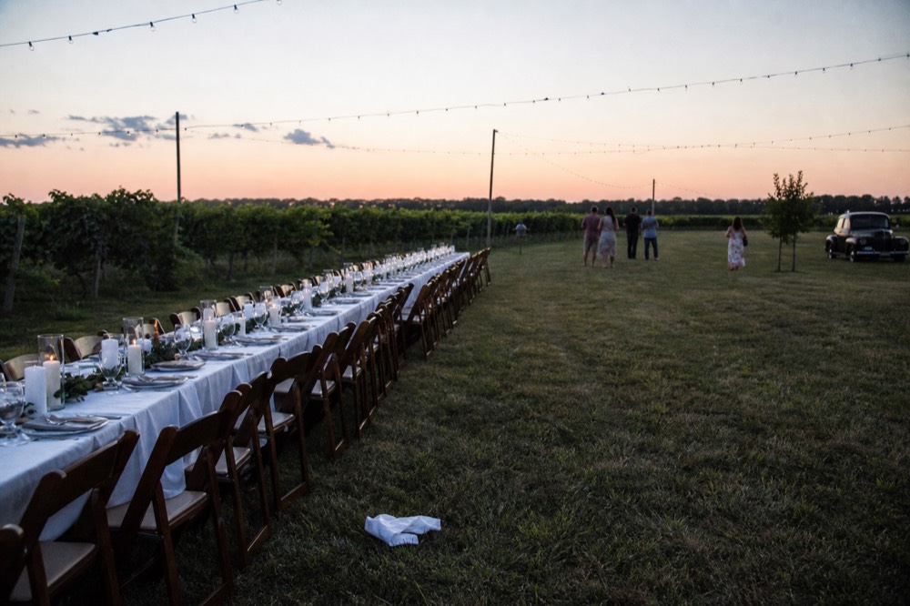 An outdoor table set for an evening event at a winery, no text, no logos, no people
