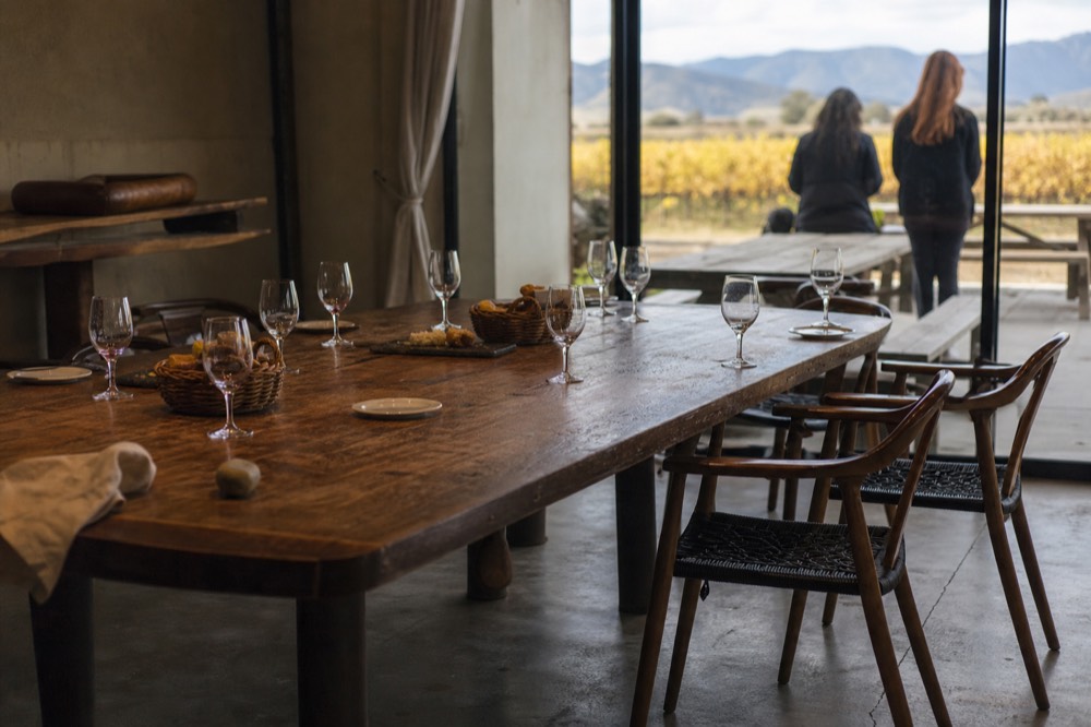 A long table set for lunch with wine glasses and bread baskets, no text, no logos, no people