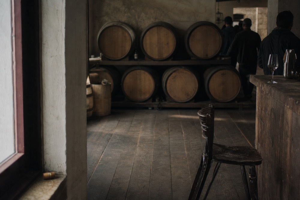 A rustic tasting room with barrels and a chalkboard-free wall, no text, no logos, no people