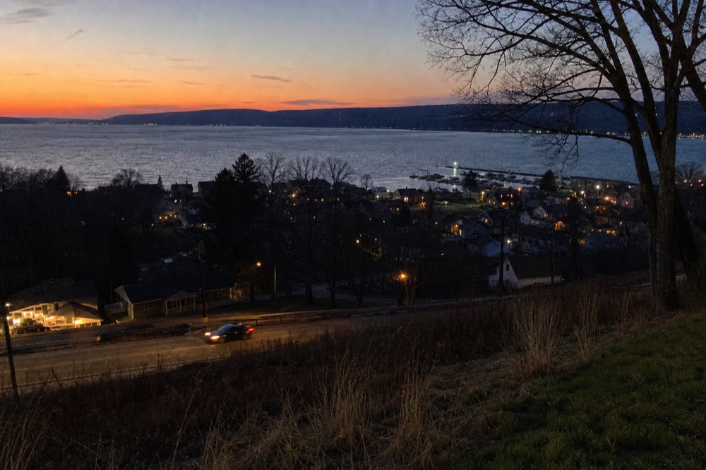 Evening view over a lake village with lights along the shore, no text, no logos, no people